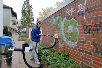 machine removing graffiti from brick